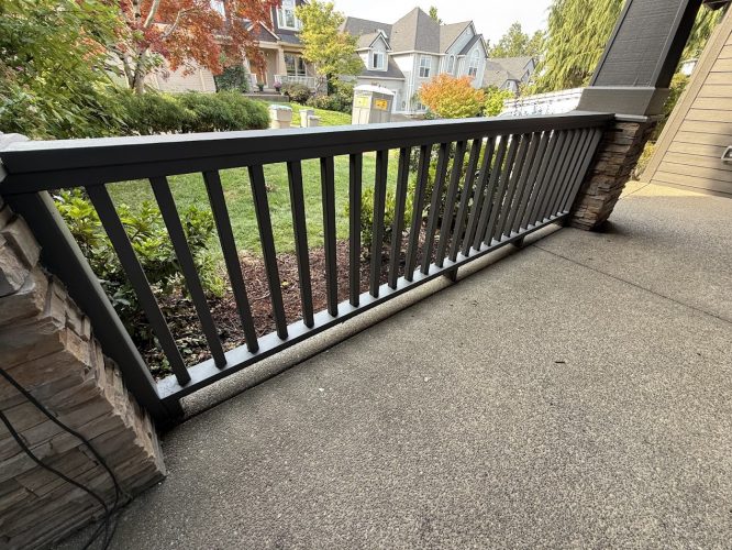 Montoya: Gray porch railing, stone pillar, yard with grass and trees. Painter or Pearl Painters could paint this scene in Portland.