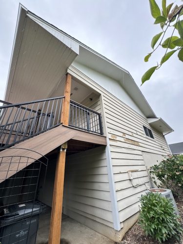 Cleveland two-story house with beige siding, black-railed stairs, and garden. Painted by Pearl Painters.