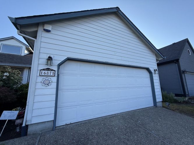 White two-car garage at 16875, suburban home. Painted by Pearl Painters, Portland. Photo from July 2025.