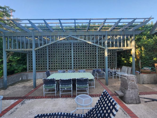 Patio with tables, chairs, and a wooden pergola by Ralph Barron in Portland; greenery, privacy screen; Pearl Painters project.