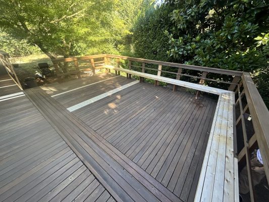 Wooden deck with benches, grill, and surrounding trees in Pitney; ideal for painting work by Pearl Painters.