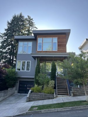 Modern two-story house with gray and wood paint, large windows; painted by Pearl Painters in Portland.