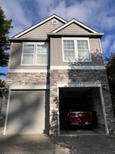 Feldon two-story house in Portland, gray siding and stone front, red car in open garage, number 4283. Pearl Painters painting.