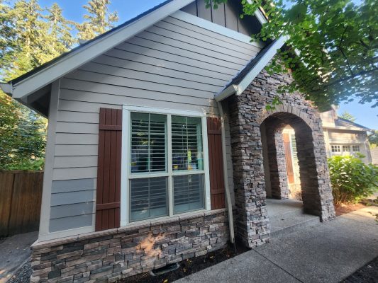 Pearl Painters painted this Holley house in Portland with beige siding, brown shutters, and stone accents amidst greenery.