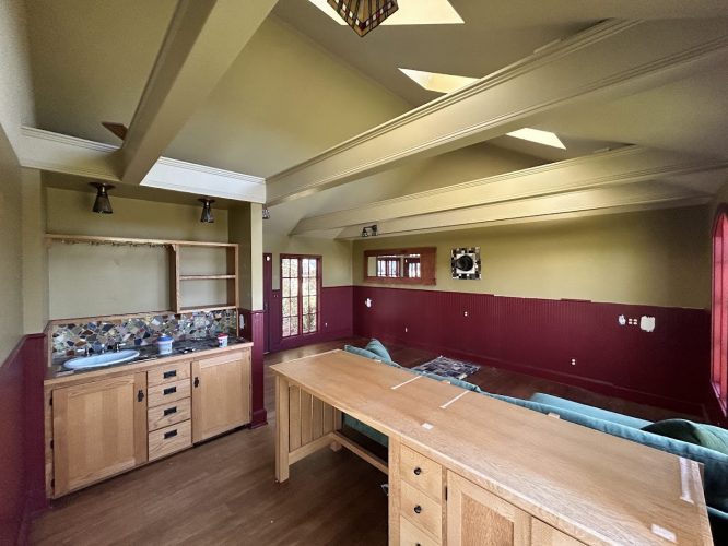 Painting by Pearl Painters in Portland: green and red walls, exposed beams, wood cabinets, green couch, unfinished backsplash.