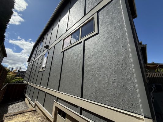 Pearl Painters painting a tall, gray stucco house with rectangular windows in Portland, July 2025.
