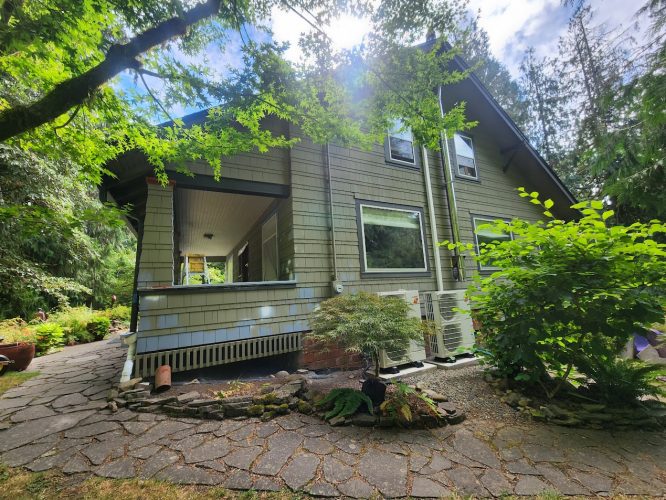A two-story Gentry house with green siding in Portland, painted by Pearl Painters, with trees and a stone walkway out front.