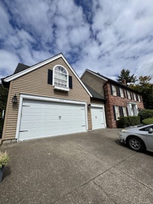 Two-story house with brown siding and white trim, painted by Pearl Painters. Photo taken in Portland, August 2025.