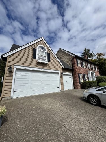 Two-story house with brown siding and white trim, painted by Pearl Painters. Photo taken in Portland, August 2025.