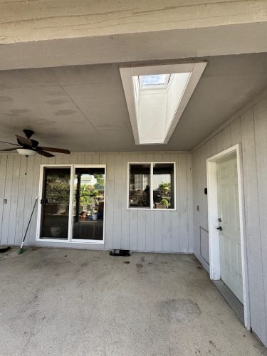 Covered patio with light gray walls painted by Pearl Painters in Portland; features sliding doors, ceiling fan, skylight.
