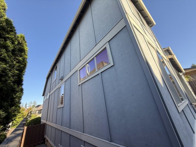 Gray two-story house with vertical siding, recently painted by Pearl Painters in Portland. Photo by Doan, July 2025.