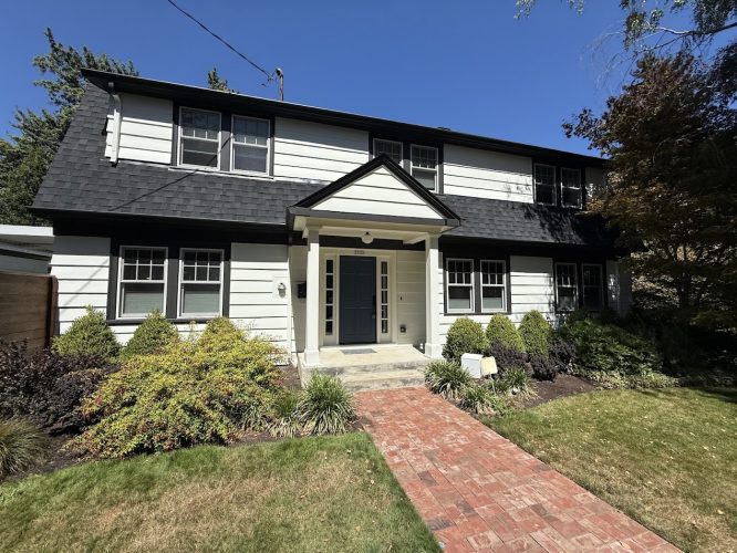 Johnson Exterior painted by Pearl Painters Portland: white siding, black trim, dark roof; ready August 2025.