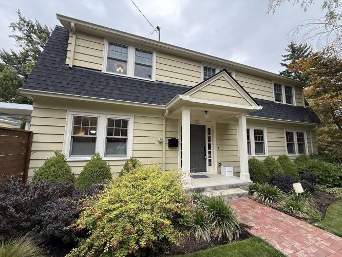 Portland: Two-story beige house with dark roof and white trim. Painted by Pearl Painters. Available August 2025.