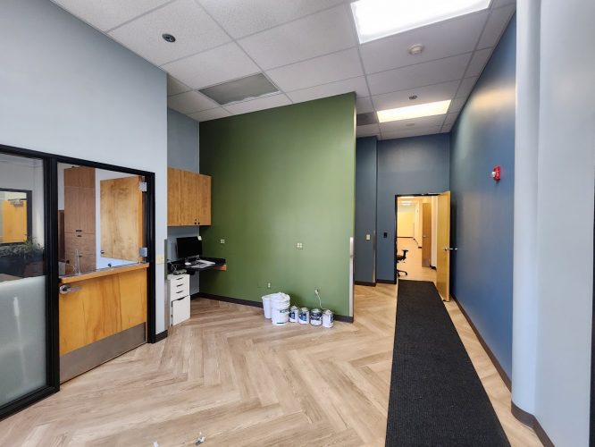 Portland office interior painted by Pearl Painters for the Jones int project, June 2025: light wood flooring, blue and green walls, built-in desk, paint cans visible.