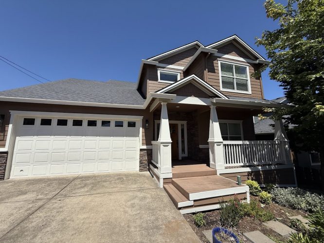 Two-story suburban house in Emory with brown siding, white trim, a front porch, and two-car garage. Painted by Pearl Painters. Located outside Portland.