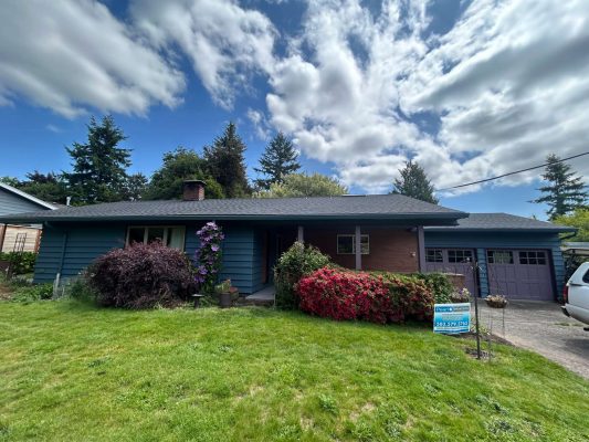 A blue single-story house in Portland features a front porch, garage, and landscaped lawn with flowering bushes. Exterior painting by Pearl Painters is highlighted. Real estate sign indicates availability for May 2025 buyers.