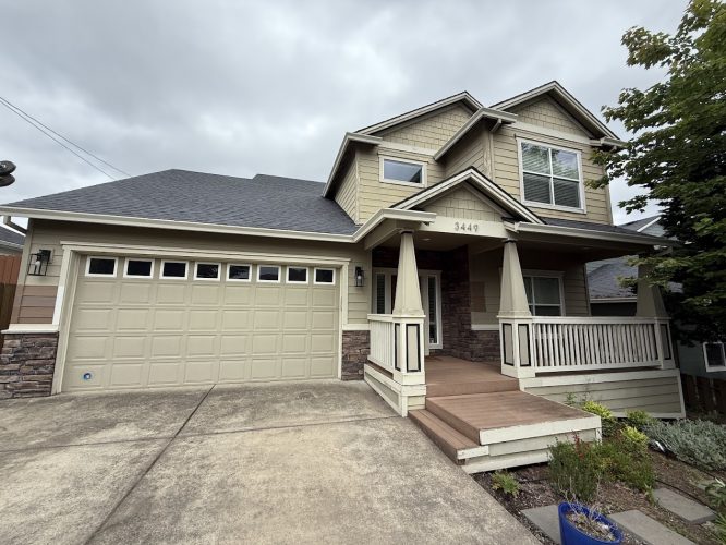 Two-story beige Emory house with front porch and attached two-car garage, located in Portland. Pearl Painters available for exterior painting June 2025.