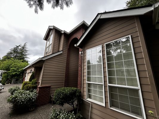 Haase exterior: Two-story brown house with white-trimmed windows, red brick accents, and landscaping. Painted by Pearl Painters, Portland.