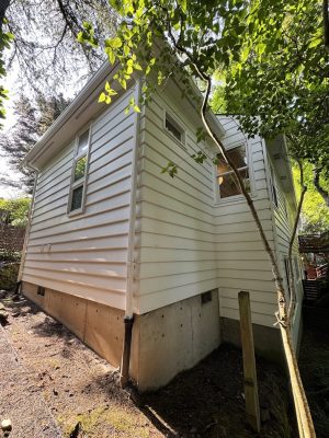 A Carlton home with vinyl siding and a concrete foundation is shown in June 2025. Painted by Pearl Painters, a Portland painting company.