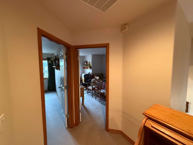 April 2025 Interior painting in Portland: A hallway with two open doors; one room has a window with curtains, the other has shelves, TV, and chairs. Pearl Painters was the painter.