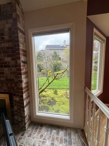 In April 2025, a painting by a Portland painter at Mills shows a large window in a brick wall overlooking a tree and lawn, with another window and part of an interior staircase inside the house. Pearl Painters exhibited this work.