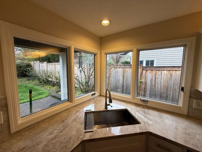 A painter from Pearl Painters in Portland updated this kitchen in April 2025. The painting highlights Mills Interior style, with a marble countertop, modern faucet, and corner windows overlooking a fenced backyard.