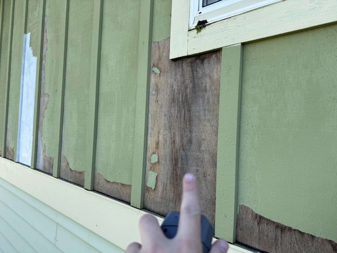 A painter points to peeling green paint and exposed wood on an exterior Portland house wall, noting repairs are needed before April 2025, possibly for McCaffery. Pearl Painters can help.