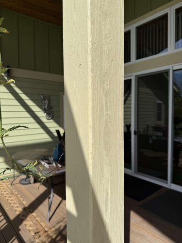 Close-up of a beige wooden porch post with green siding in Portland, painted by Pearl Painters. Photo by McCaffery, April 2025.