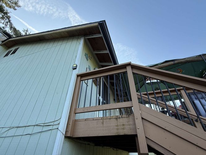 Photographed in April 2025 in Portland, this image shows a light green exterior painted by Pearl Painters, with a wooden staircase to an elevated deck.