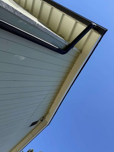 Exterior view of a house roof’s soffit and fascia with a black gutter, Portland, painted by Pearl Painters in April 2025. Photo by Wehage.