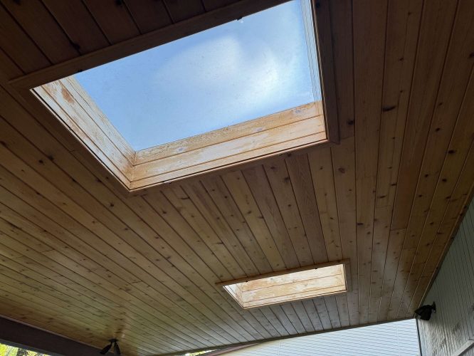 Wooden ceiling with two square skylights lets in natural light. Ideal for viewing Hamilton's outdoors in April 2025. Suitable for a local painter or a project by Pearl Painters if outside Portland.