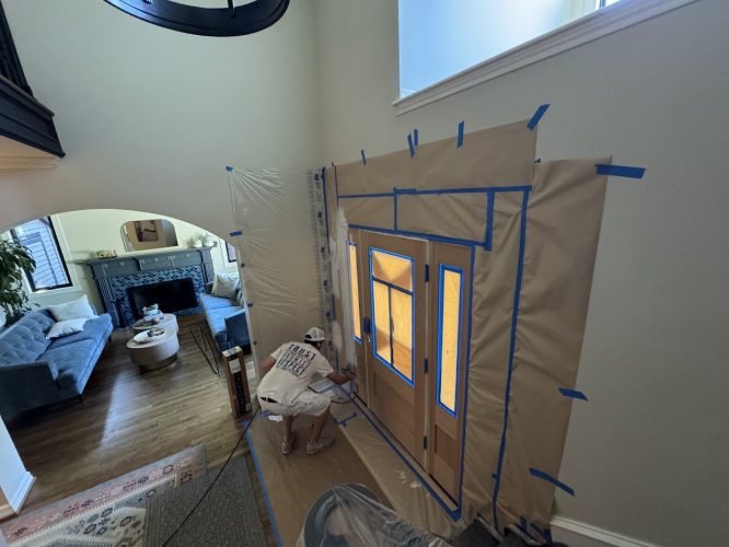 Painter taping and painting interior trim by a front door in Portland; prep for Pearl Painters' July 2025 exterior refresh.