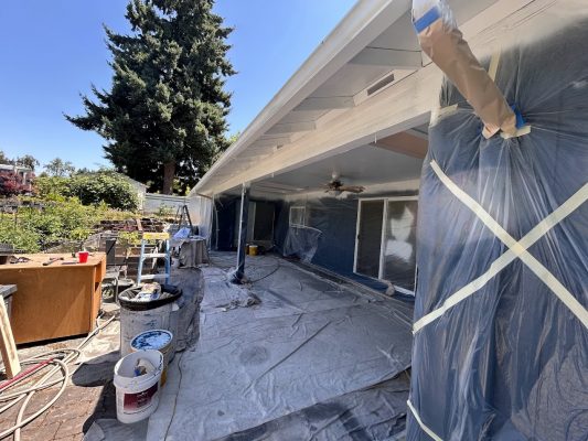 Portland patio prepped for painting by Pearl Painters, with plastic sheets, drop cloths, and painter's supplies visible.