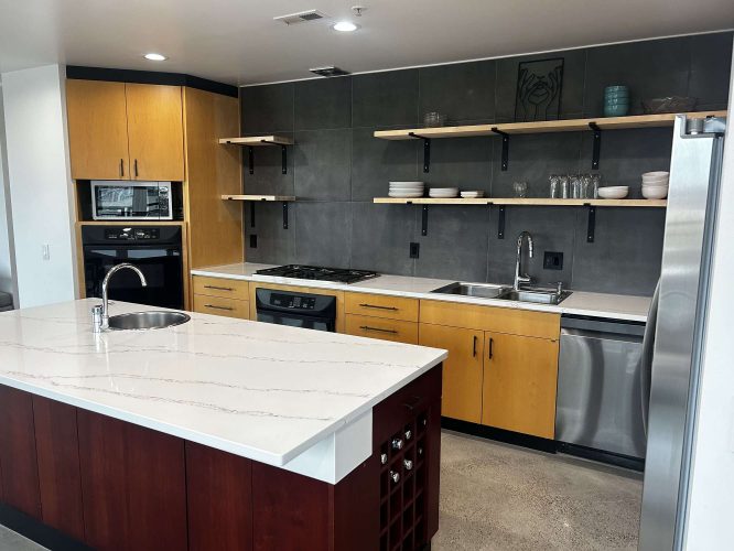 Modern Portland kitchen with Isadore wood cabinets, marble countertops, open shelves, and stainless steel appliances. Ideal for an April 2025 painting refresh by Pearl Painters.