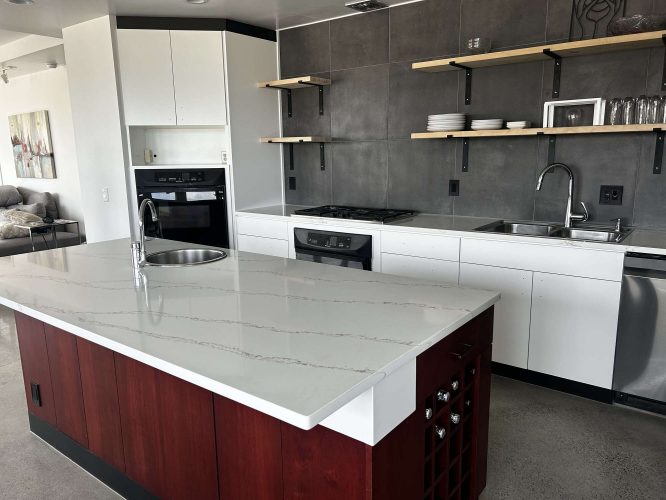 Modern kitchen in Portland with sleek Isadore Cabinets, marble island, built-in oven, gas stove, dishwasher, open shelves, and gray tile backsplash—ready for a fresh painting by Pearl Painters in April 2025.