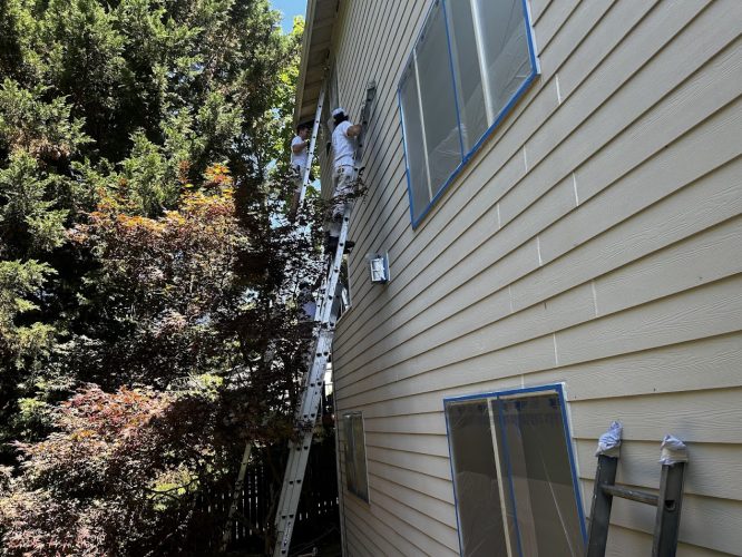 In July 2025, painters on ladders paint a beige Jennings house; Pearl Painters cover windows with tape and plastic.