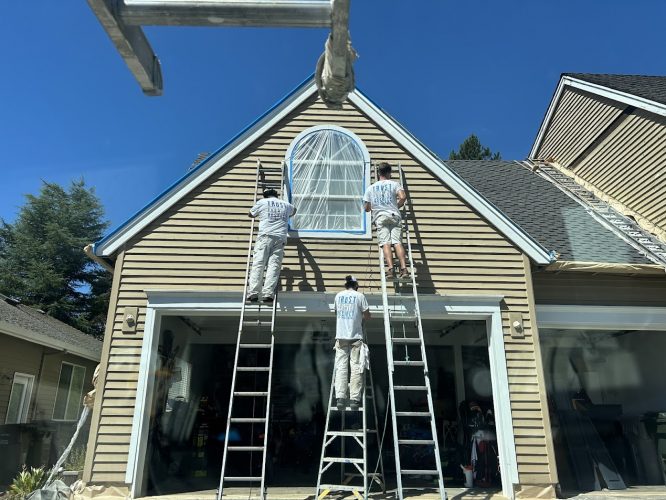 Three painters from Pearl Painters paint a beige house with an arched window for Renee & Seamus Barron in Portland, Aug 2025.