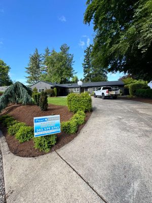 Pearl Painters completed painting this gray, single-story house in Portland in May 2025. A sign with their name is displayed on the front lawn.
