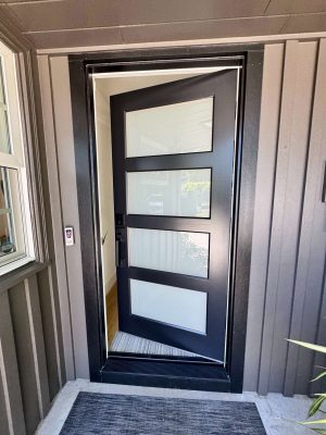 Pearl Painters painted the Mastalir home in Portland in May 2025. The painting features a modern black front door with four frosted glass panels, vertical siding, and an exterior window.