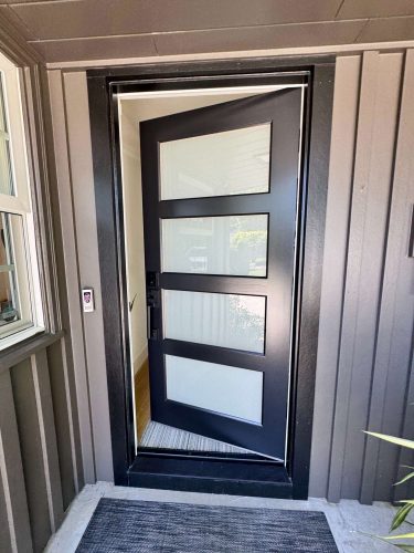 Pearl Painters painted the Mastalir home in Portland in May 2025. The painting features a modern black front door with four frosted glass panels, vertical siding, and an exterior window.