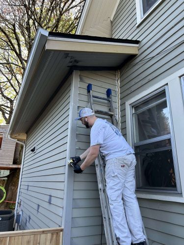 In April 2025, a painter with Pearl Painters measures the exterior siding of a Congdon house in Portland.
