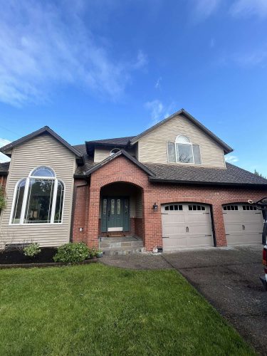 Two-story suburban house with brick and siding exterior, double garage, and large windows. Located in Portland. Painting available from Pearl Painters in April 2025. Contact Scott for details.