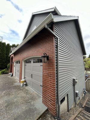 Pearl Painters, a Portland painting company, will complete Scott’s two-car garage exterior project—featuring red brick, gray siding, and gray doors—by April 2025.