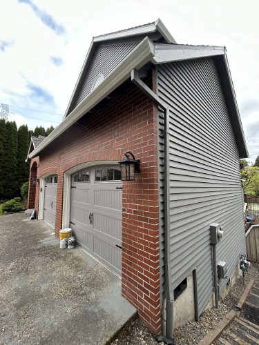 Pearl Painters, a Portland painting company, will complete Scott’s two-car garage exterior project—featuring red brick, gray siding, and gray doors—by April 2025.