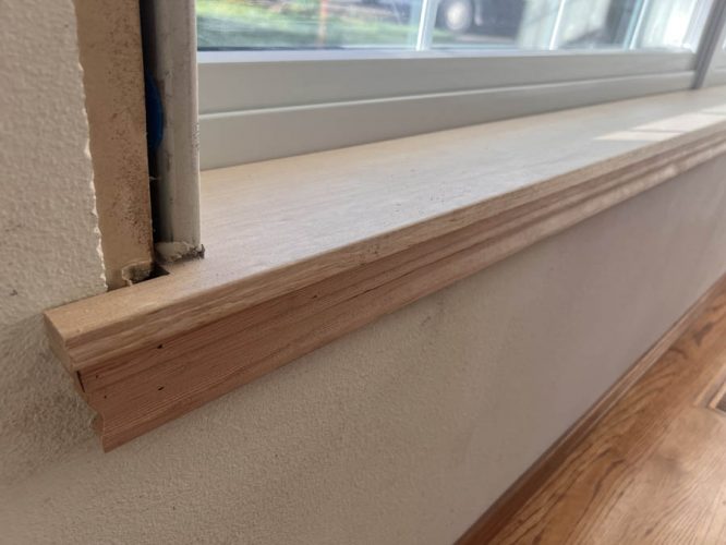 A close-up of an unfinished wooden window sill after window replacement in Happy Valley, OR