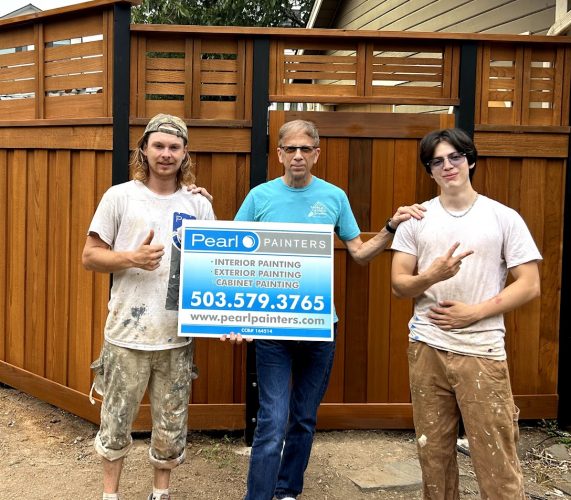 Three men hold a Pearl Painters sign for painting services in Portland, showing phone number and website.