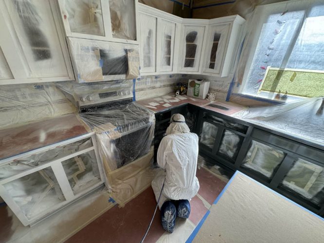 Pearl Painters team member inside kitchen working on cabinets