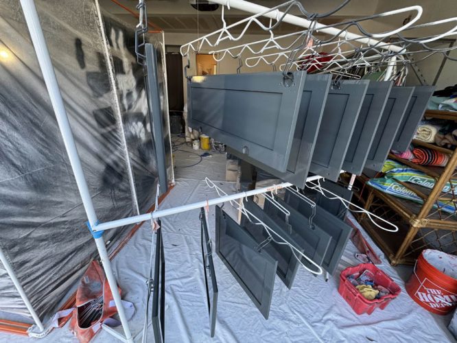 Professionally painted kitchen cabinet doors hanging in garage to dry