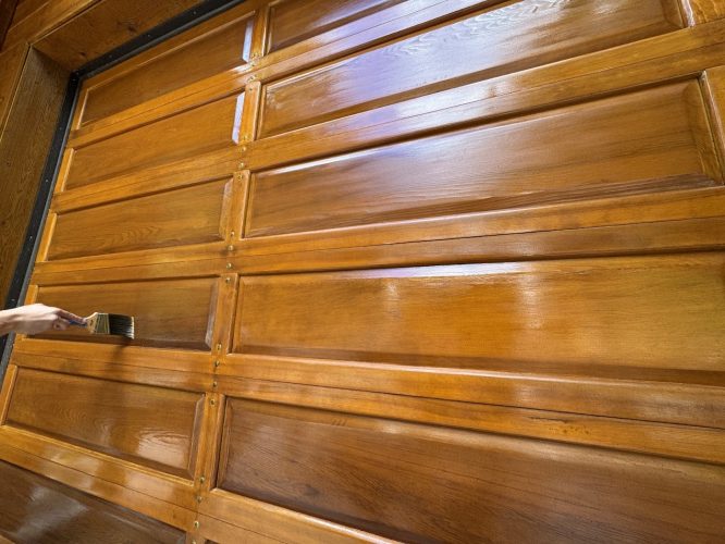 Pearl Painters painting a wooden garage door.