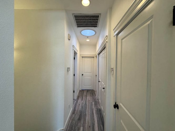 Interior hallway with several doors and hard flooring with fresh paint
